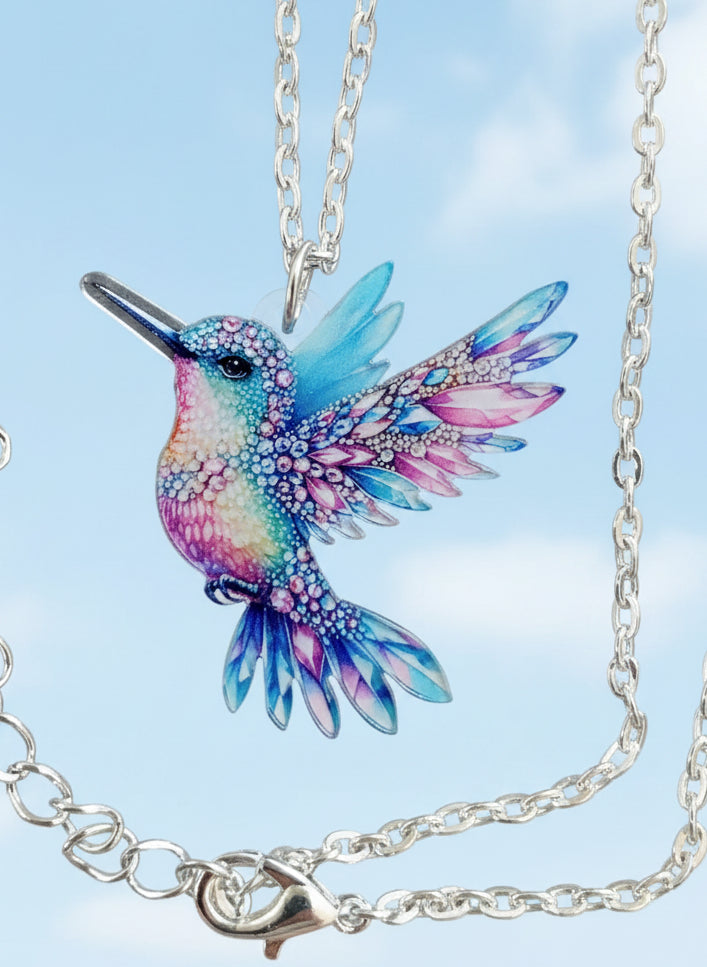 Kolibri Kette blau rosa mit silberfarbener Kette auf schwarzem Hintergrund