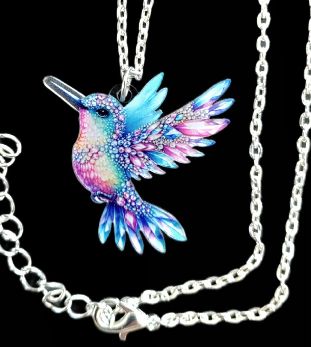 Kolibri Kette blau rosa mit silberfarbener Kette auf schwarzem Hintergrund